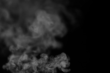 White smoke on a black background. Texture of smoke. Clubs of white smoke on a dark background for an overlay