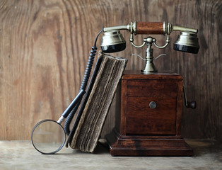 Old telephone and retro book on a wood