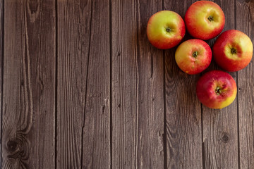 Red apples on wooden dark background. Autumn harvest. Flat lay. Copy space