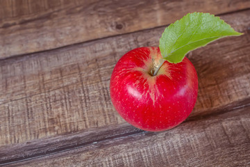 Red apple on dark wooden background. Autumn harvest. Selective focus.
