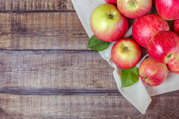 Red apples on dark wooden background. Autumn harvest. Flat lay. Selective focus.