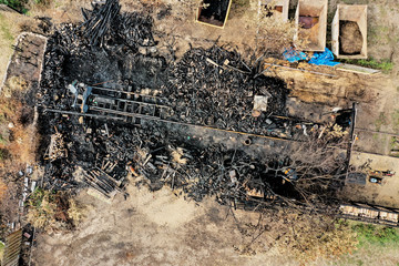 Aerial view of a wooden building completely destroyed by fire with burnt wood, perpendicular...
