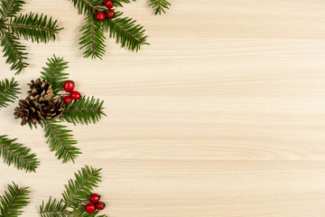 Christmas composition. Tree branches, pine cone and berries on wooden background. Christmas, winter, new year concept. Flat lay, top view, copy space
