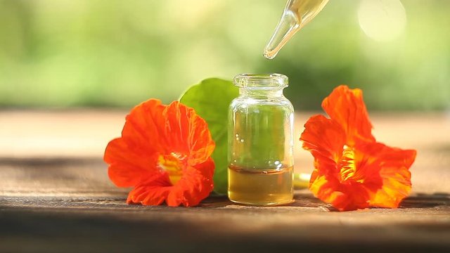 nasturtium essential oil in  beautiful bottle on wooden background
