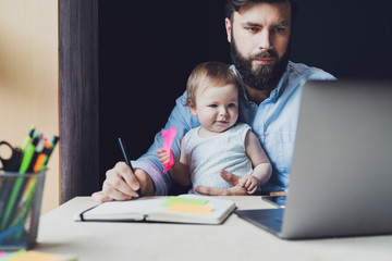 Parent with child studying remotely at homebased laptop. Distant education for people with babies....