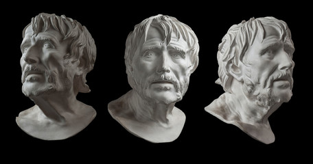 Three gypsum copy of ancient statue head of Lucius Seneca isolated on black background. Plaster...