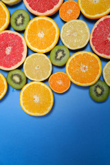Citrus fruits vegan vitamin mix flat lay on blue background, healthy vegetarian organic food, antioxidant detox diet. Fruit background with copy space. 