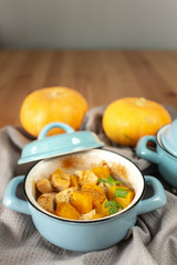 Pumpkin roast in a blue pan on a wooden table
