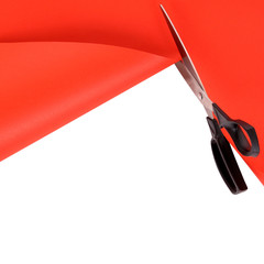 Scissors cutting red paper background
