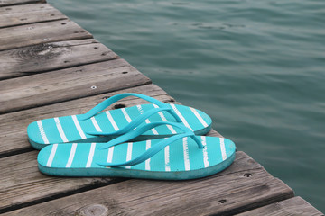 Flip flops at the wooden pier at lake	