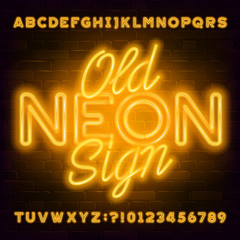 Old Neon Sign alphabet font. Yellow neon light letters and numbers on brick wall background. Stock vector typeface for your typography design.