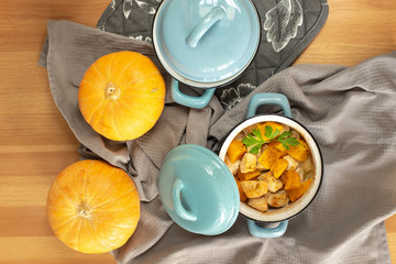 Pumpkin roast in a blue pan on a wooden table