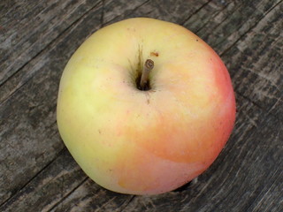 Ripe juicy Apple on the background of old wood.