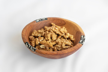 Chestnuts  in wooden bol as appertiser with drinks against a white background