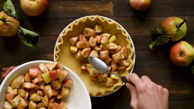 Cooking process of apple pie. Pastry dough with apple pie filling on a wooden table background, top view. Autumn comfort food