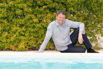 handsome man sitting floor garden near pool deck