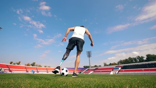 A man with a prosthetic leg is playing with a ball