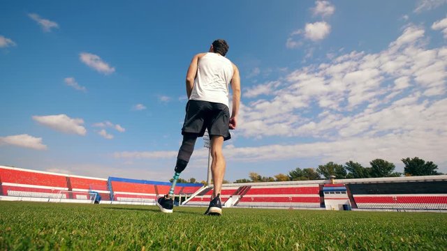 Handicapped athlete is hitting a football