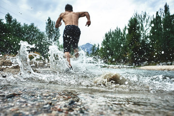 Asian athlete on a morning run on the river, Kazakh jogger in nature close-up