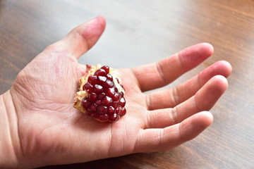 red pomegranate grains on hand,
