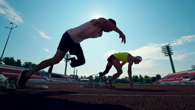 Men with prosthetic legs are getting ready and start running