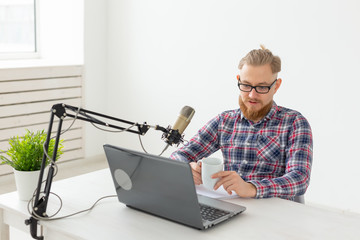 Radio host, streamer and blogger concept - Handsome man working as radio host at radio station...
