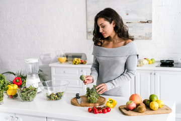young attractive woman preparing salad at home