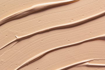 Makeup foundation creamy texture background. Skin tone cosmetic cream diagonal strokes. Beige make...