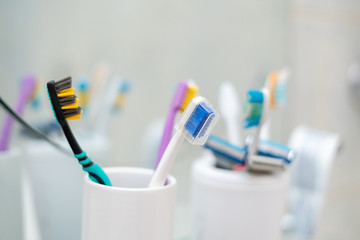 set of some colorful toothbrushes razor blades on the shelf in bathroom, personal accessories