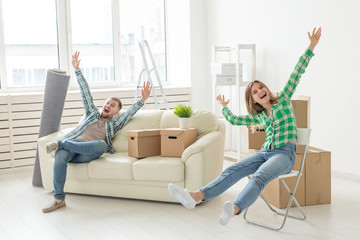 Positive smiling young girl sitting against her laughing in a new living room while moving to a new home. The concept of joy from the possibility of finding new housing.