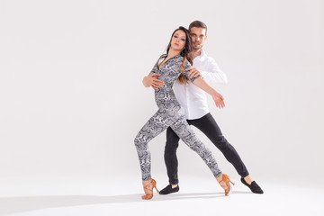 Young couple dancing latin dance bachata, merengue, salsa, kizomba. Two elegance pose over white background with copy space