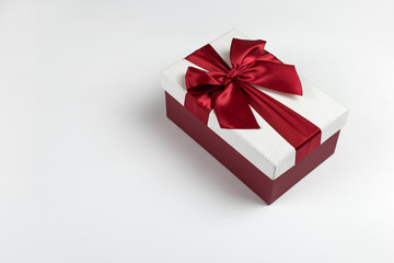 Gift with a red ribbon and a bow on a white background, copy space.