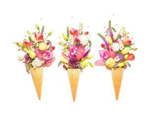Three waffle cones with flowers on white background