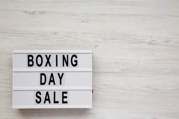 'Boxing day sale' words on a modern board on a white wooden surface, top view. Overhead, from above, flat lay. Space for text.