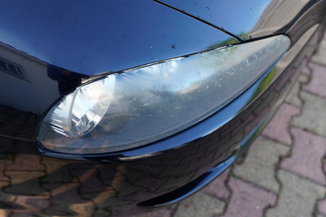 Car front damaged opaque blurred headlight surface result of weather