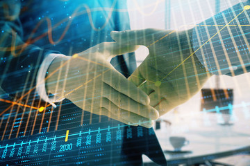 Multi exposure of financial graph on office background with two businessmen handshake. Concept of success in business