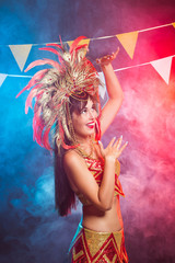Carnival, dancer and holiday concept - Beauty brunette woman in cabaret suit and headdress with natural feathers and rhinestones.