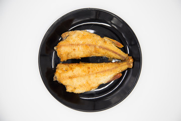 Fried river perch on a black plate. Natural eco fresh water - river fish  on a white background.