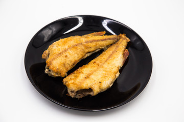 Fried river perch on a black plate. Natural eco river fish  on a white background.