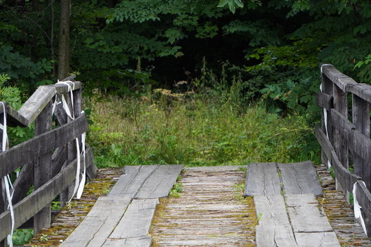 wooden road or bridge with old railings across the river. bottom view, copyspace