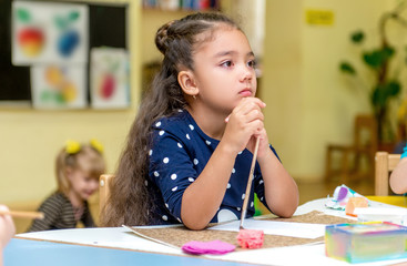 little girl in a drawing lesson in kindergarten