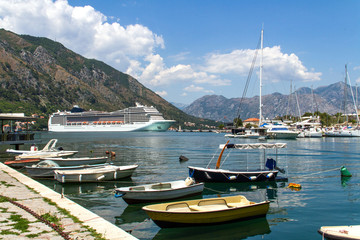 Fototapeta na wymiar Kotor, Montenegro. A view to the Boka Kotor bay, small boats and giant sea liner.
