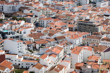 Fototapeta na wymiar Red and Orange roofs of Nazare fishing village captured from Upper Town in Nazare, Portugal