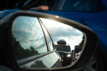 View in the side mirror of a car on the road. Traffic congestion, a large congestion of cars, difficult traffic.