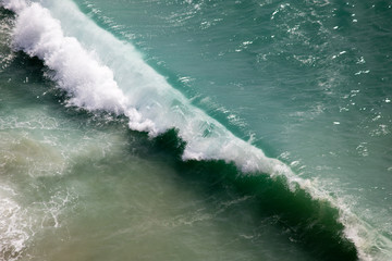 Beautiful crushing wave of Atlantic ocean, captured during the walk along the sandy beach in...