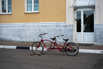 Fototapeta na wymiar Red Tandem bike. Picture of tandem bicycle on the street city