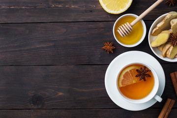 White Cup with natural herbal tea ginger lemon and honey cinnamon. Energy vitamin drink is used for colds.Dark wooden background copy space