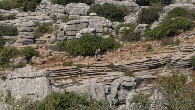 Hikers hiking with karst rocks in the natural reserve of Torcal, Antequera