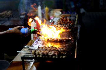 chef on fire flaming cooking bbq sea food.