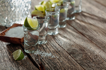 Tequila with  salt and lime on a old wooden background.